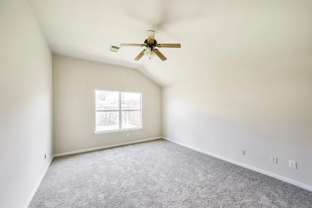 an empty room with windows and fan