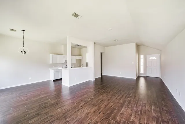 a view of empty room with wooden floor