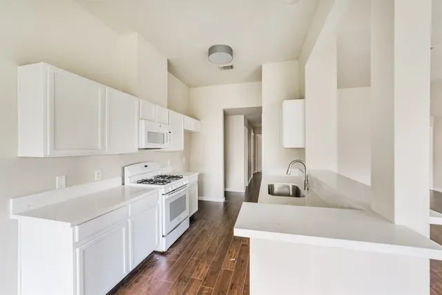 a kitchen with a sink a stove and cabinets
