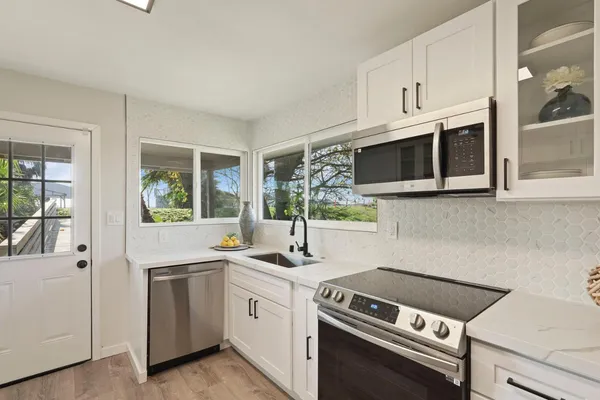a kitchen with stainless steel appliances white cabinets and a sink