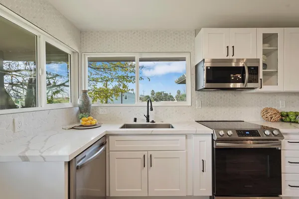 a kitchen with stainless steel appliances a stove a sink and a microwave