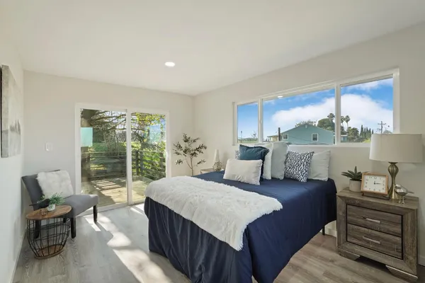 a spacious bedroom with a bed and wooden floor