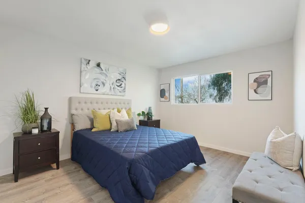 a bedroom with a bed and painting on the wall