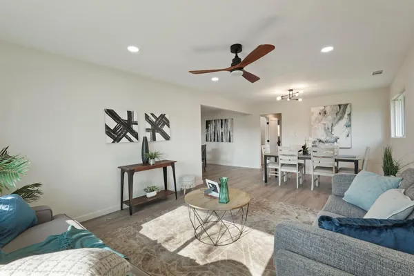 a living room with furniture and a wooden floor