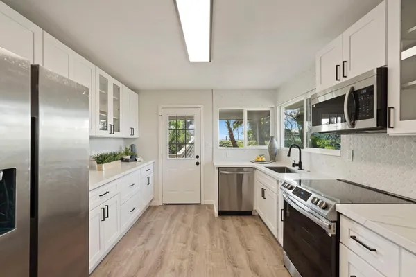 a kitchen with stainless steel appliances a sink stove and refrigerator
