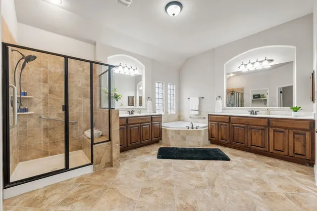 a large white bathroom with a large tub and shower