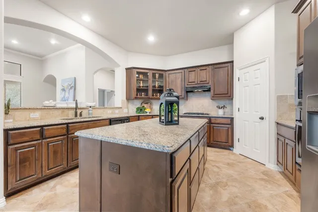 a kitchen with stainless steel appliances granite countertop a sink stove and refrigerator