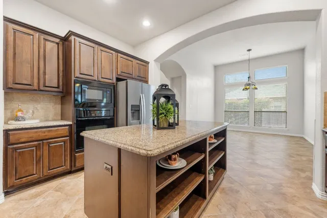 a kitchen with stainless steel appliances granite countertop a stove a sink and a refrigerator