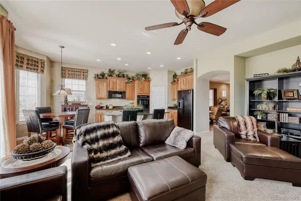 a kitchen with granite countertop a table chairs stove and refrigerator