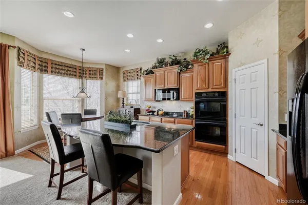 a kitchen with sink refrigerator dining table and chairs