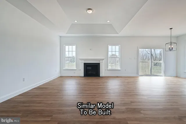 an empty room with wooden floor and fireplace