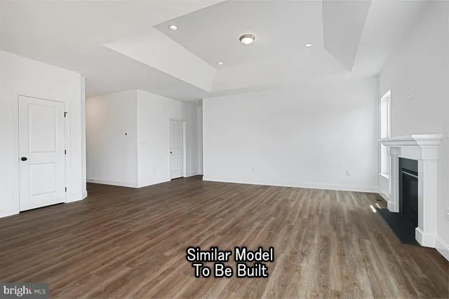 an empty room with wooden floor and fireplace