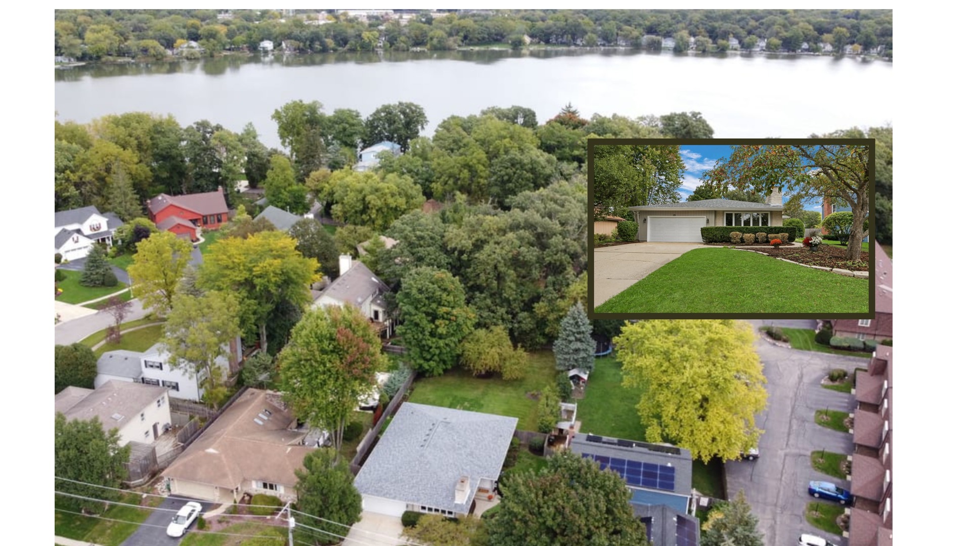 an aerial view of a house with lake view and houses in the back