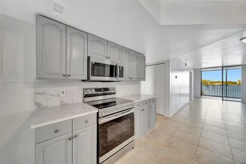 a large kitchen with cabinets stainless steel appliances and a counter space