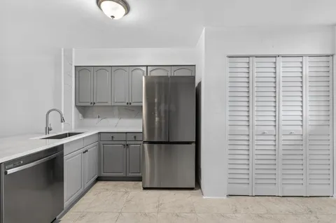 a kitchen with stainless steel appliances granite countertop a refrigerator and a stove top oven