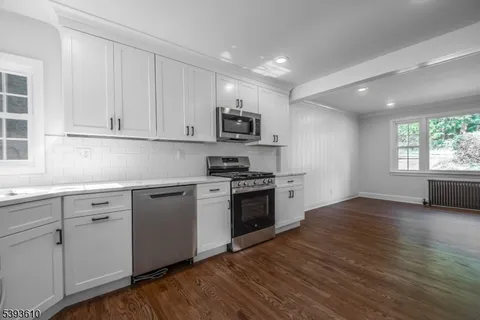 a kitchen with granite countertop a stove a sink and a microwave