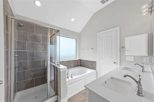 a bathroom with a tub sink and mirror