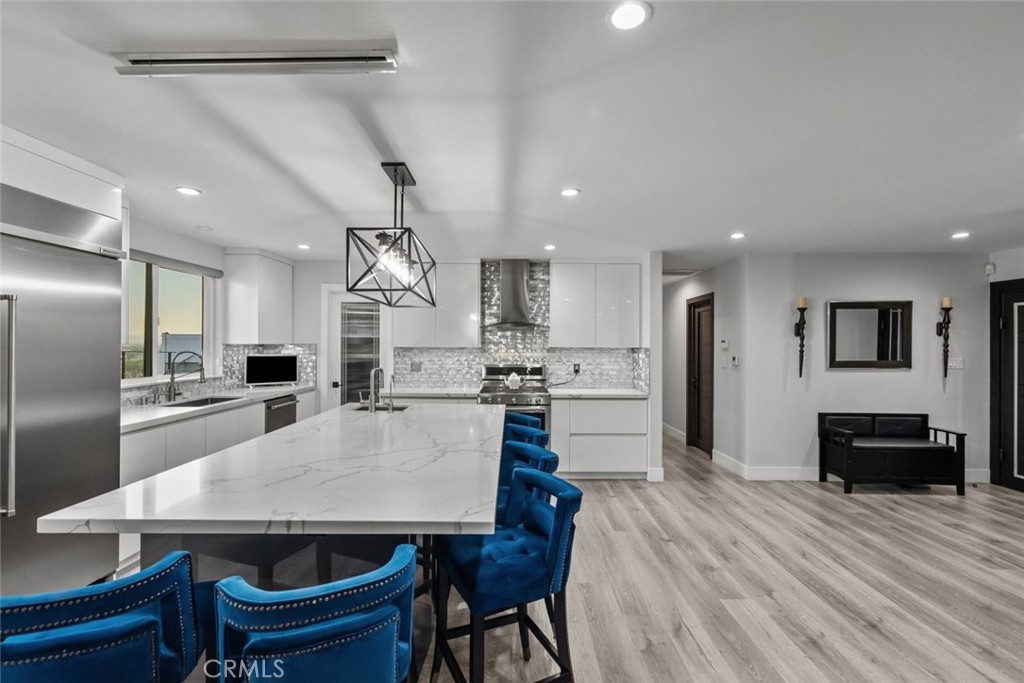 10126 Sully Drive Sun Valley, CA 91352 - Photo 12 of 34 a kitchen with stainless steel appliances a dining table chairs and wooden floor
