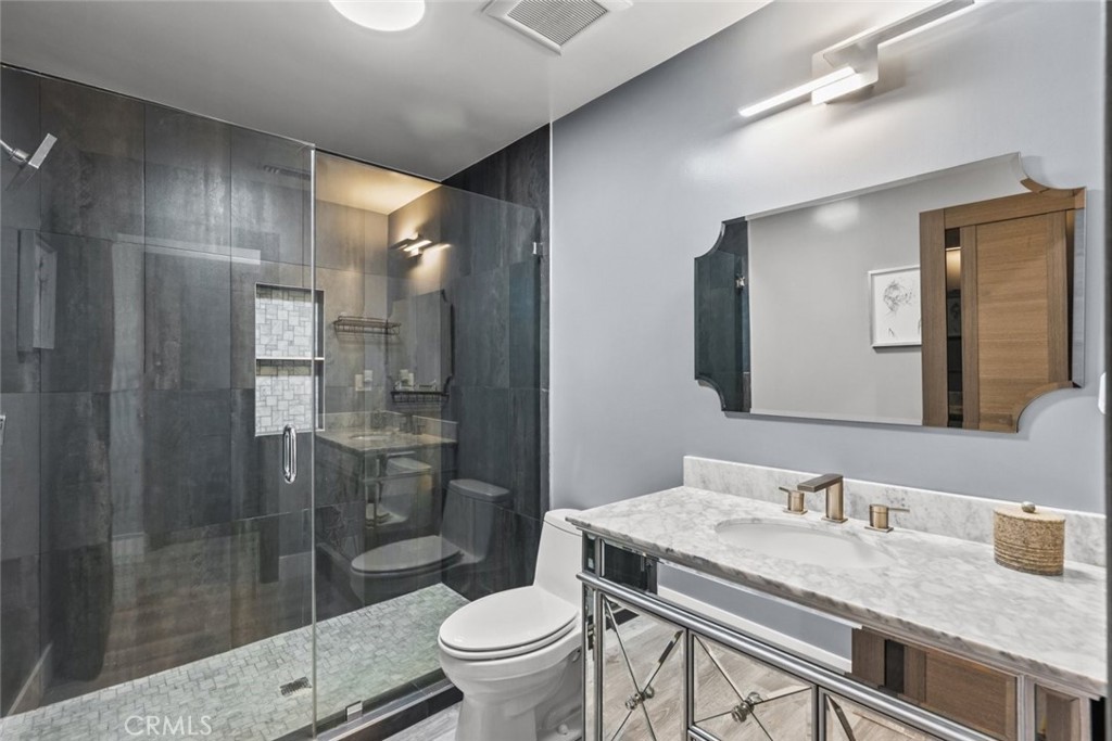 10126 Sully Drive Sun Valley, CA 91352 - Photo 23 of 34 a bathroom with a granite countertop sink a toilet a mirror and shower