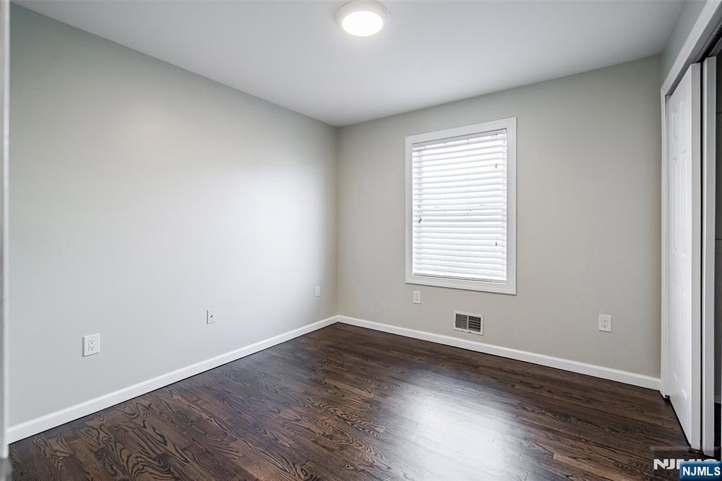 312 Vine Street Elizabeth, NJ 07202 - Photo 5 of 10 an empty room with wooden floor and windows