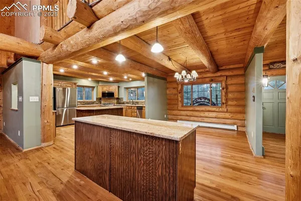 a open kitchen with stainless steel appliances granite countertop a sink and wooden floors