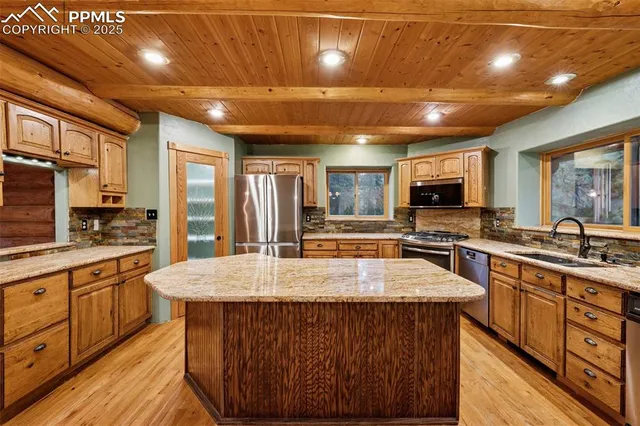 a large kitchen with lots of counter space a sink appliances and cabinets