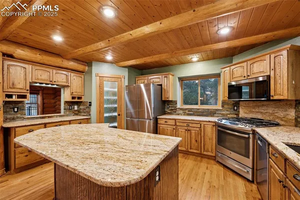 a kitchen with stainless steel appliances granite countertop sink stove top oven and refrigerator
