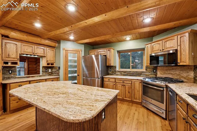 a kitchen with stainless steel appliances granite countertop sink stove top oven and refrigerator