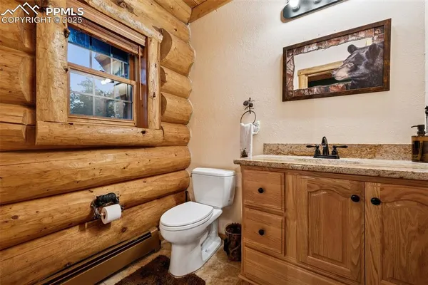 a bathroom with a granite countertop toilet sink and mirror