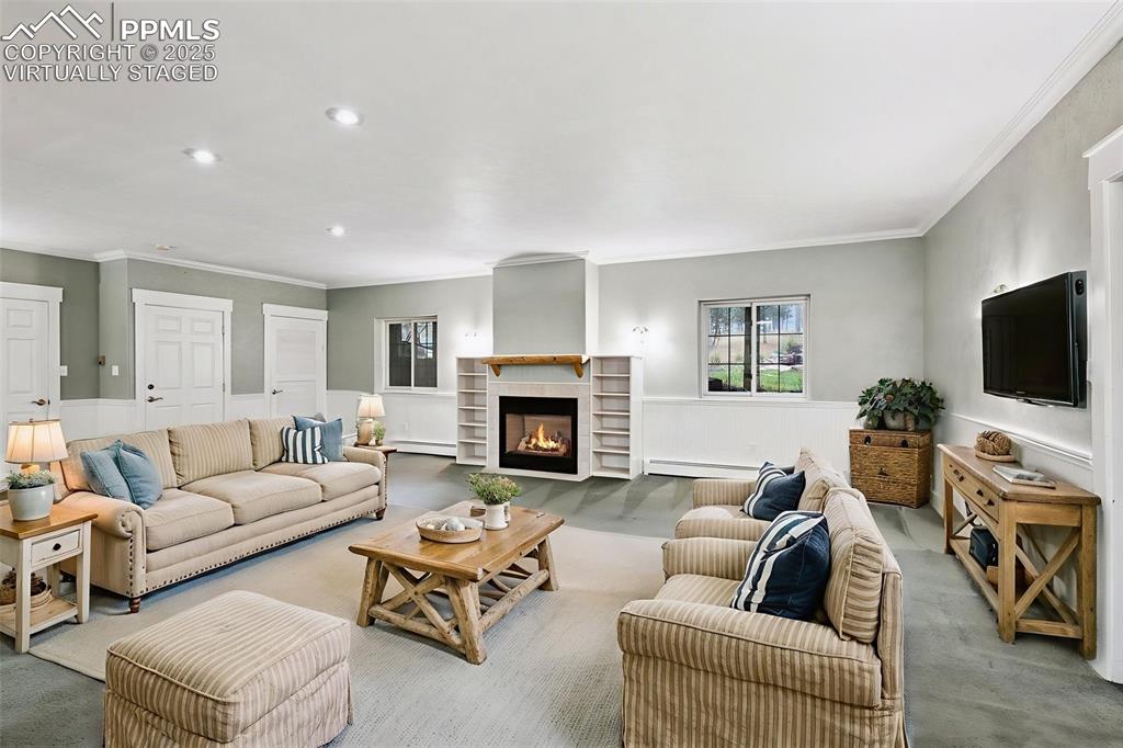 17522 Abert Ridge View Colorado Springs, CO 80908 - Photo 36 of 46 a living room with furniture a fireplace and a flat screen tv