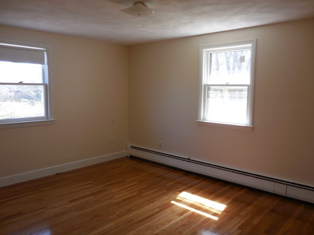 28 Lillian Road Lexington, MA 02420 - Photo 5 of 10 an empty room with wooden floor and windows