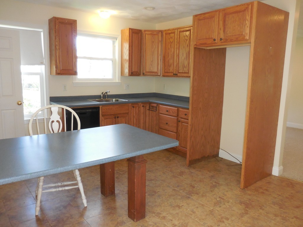 28 Lillian Road Lexington, MA 02420 - Photo 8 of 10 a kitchen with stainless steel appliances granite countertop a sink refrigerator stove and microwave