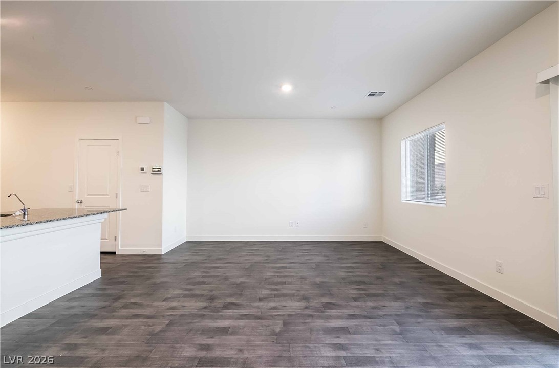 12749 Epperly Street Henderson, NV 89044 - Photo 5 of 22 Bright, naturally illuminated open-concept space featuring durable plank flooring and convenient breakfast bar.