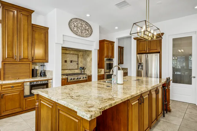 a view of a dining room with furniture a kitchen and chandelier