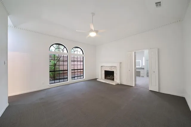 a view of an empty room with a fireplace and a window