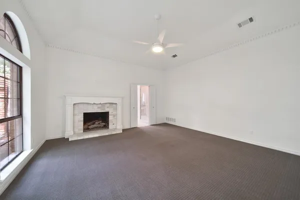 a view of an empty room with a fireplace and a window