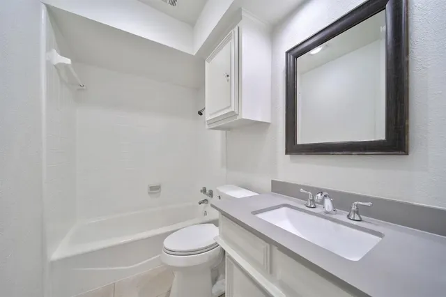 a bathroom with a toilet a sink a mirror and bathtub