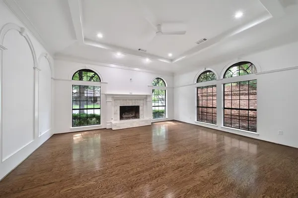 an empty room with windows and fireplace