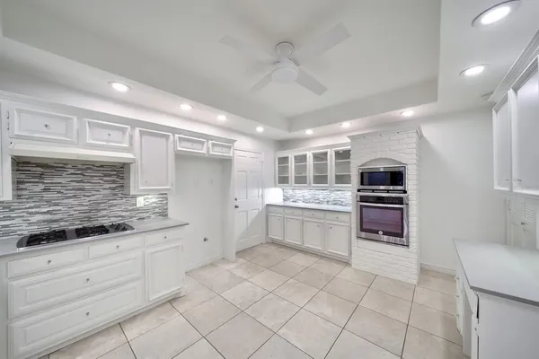 a large white kitchen with a stove a sink dishwasher and a refrigerator