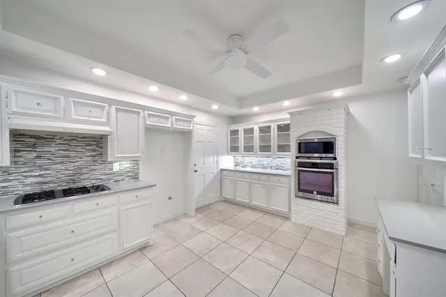 a large white kitchen with a stove a sink dishwasher and a refrigerator