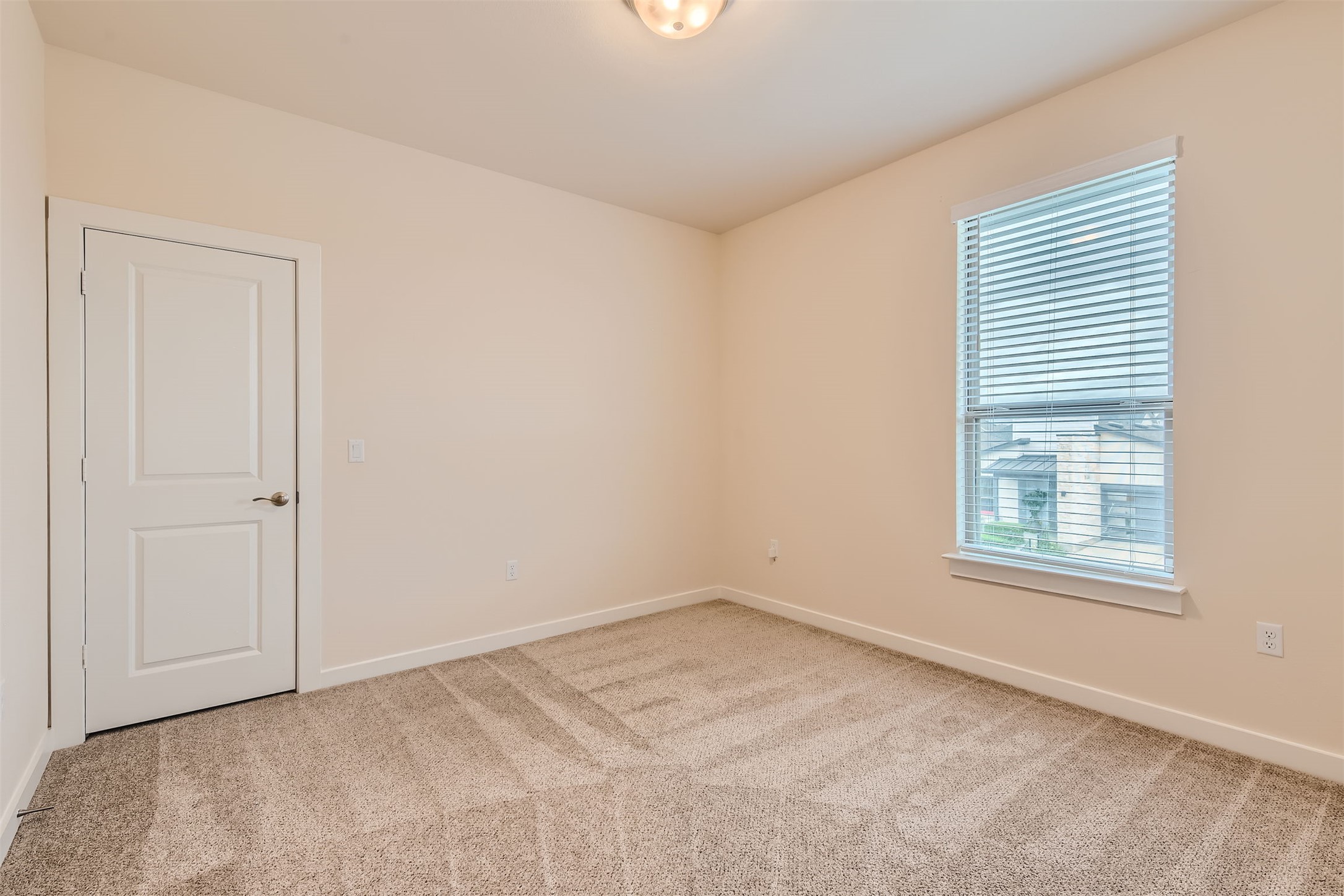 8313 Spire View Austin, TX 78744 - Photo 23 of 33 A well-lit bedroom features plush carpeting and a large window, ready for personalization.