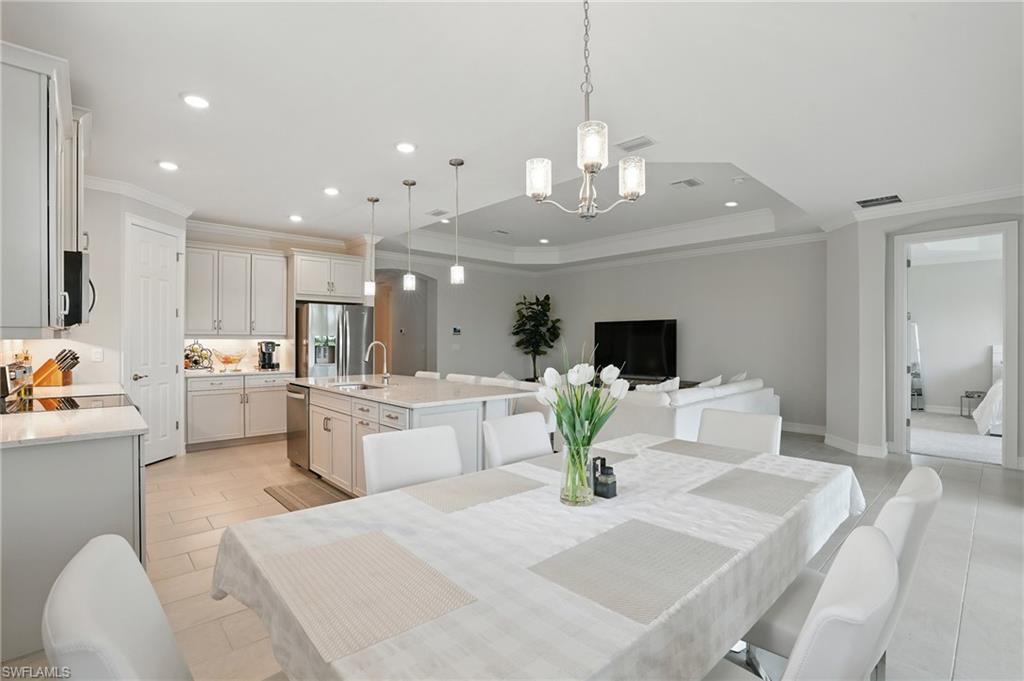 28165 Captiva Shell Loop Bonita Springs, FL 34135 - Photo 13 of 38 a living room with kitchen island furniture and a chandelier