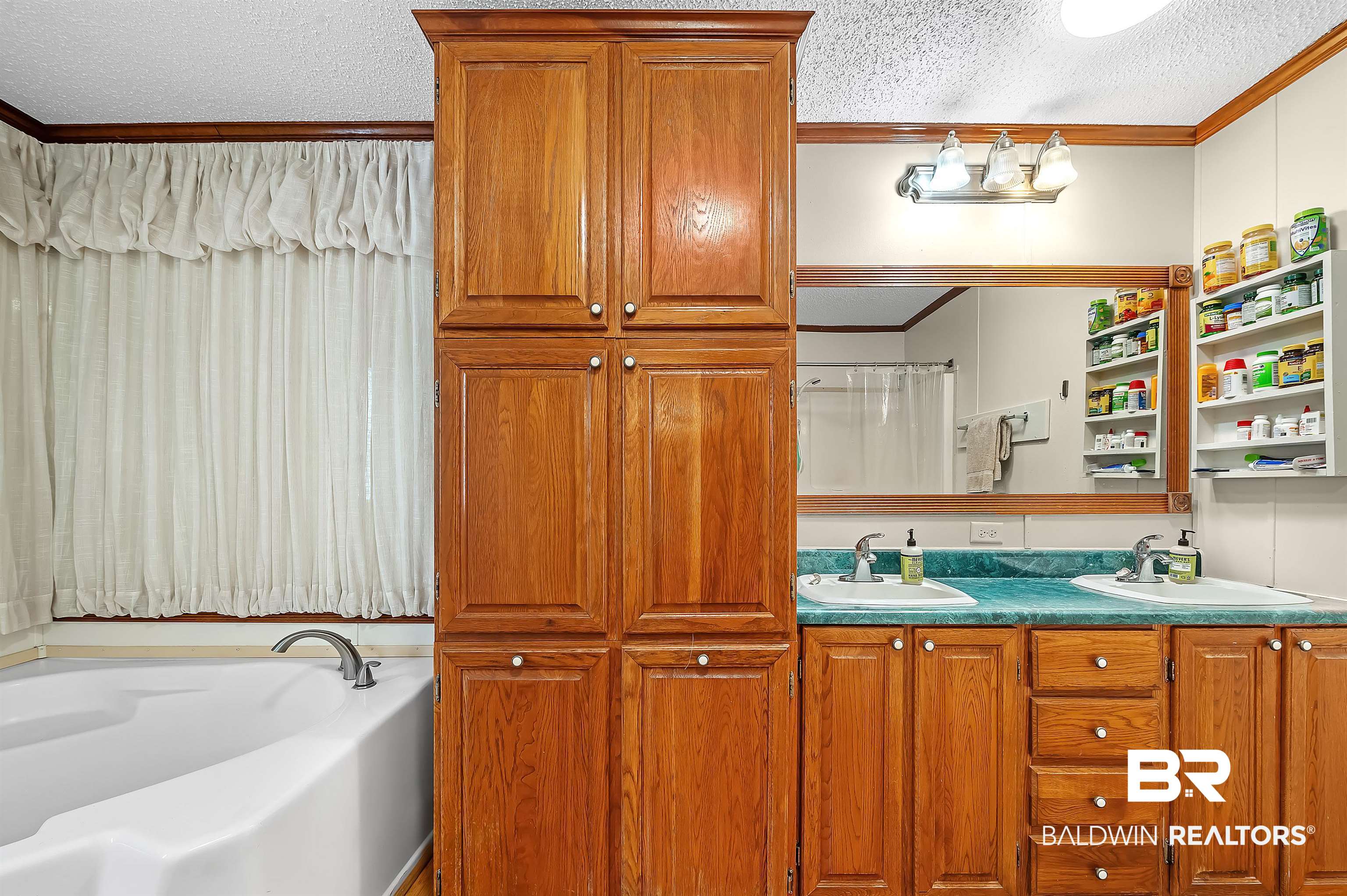 10970 Stucki Road Elberta, AL 36530 - Photo 29 of 56 Bathroom with dual bowl vanity, a bathtub, and a textured ceiling