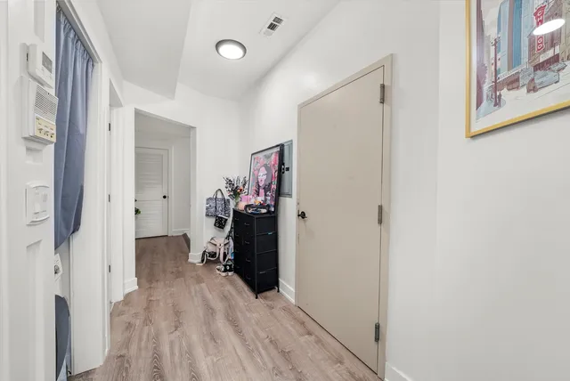 a view of a hallway with closet and a window