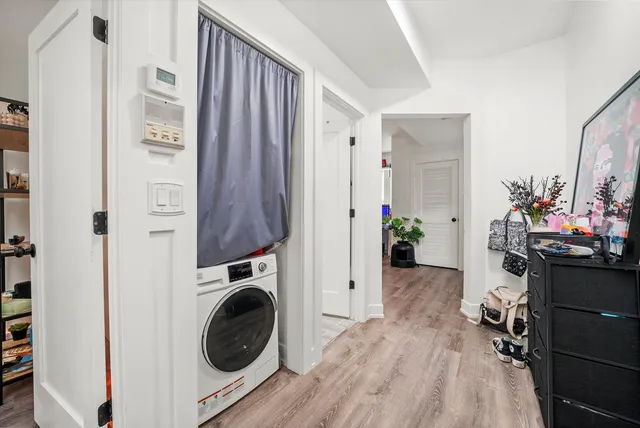 a view of a hallway and a dining room with wooden floor