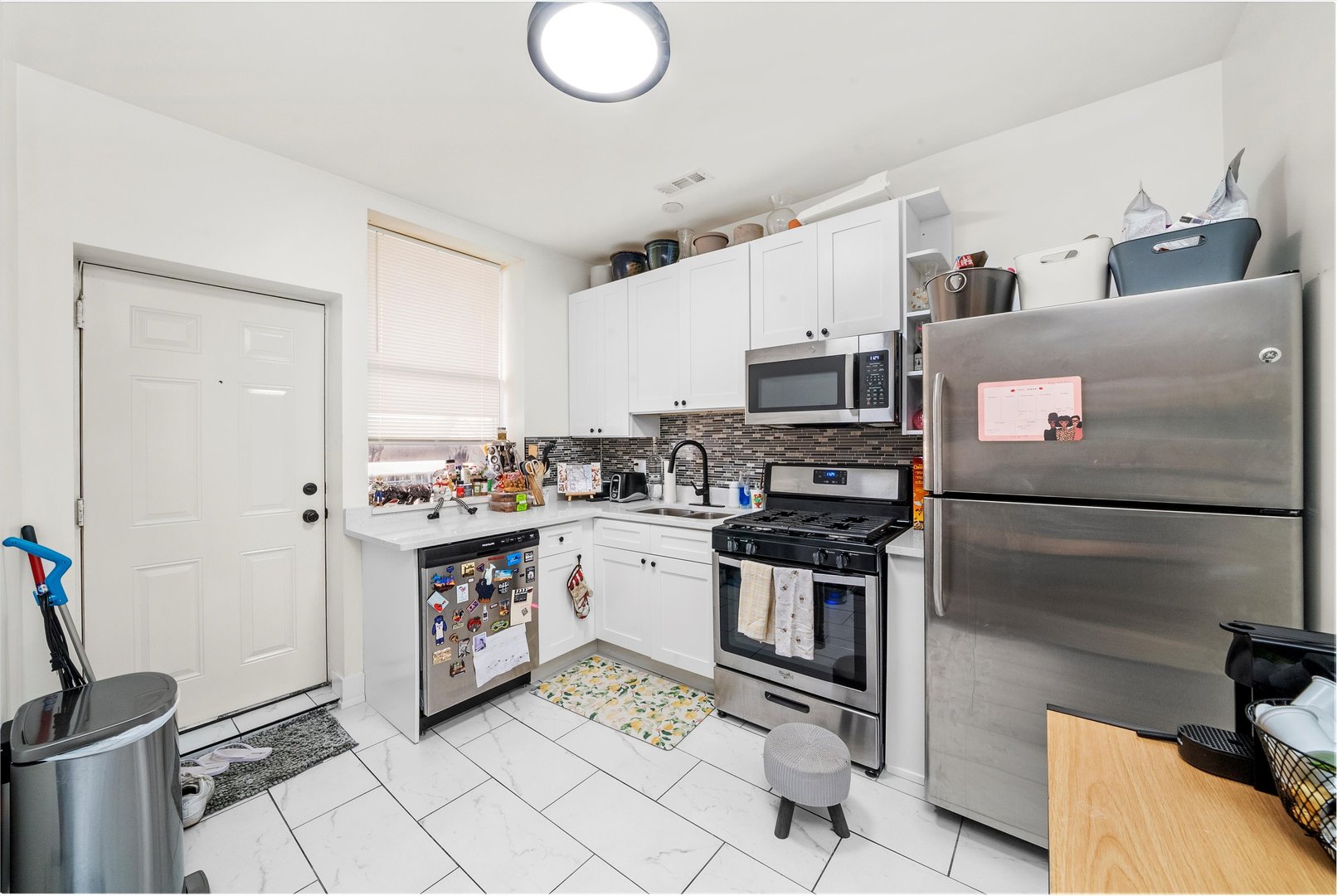5004 South Champlain Avenue, Unit 1 Chicago, IL 60615 - Photo 9 of 15 a kitchen with granite countertop a sink stainless steel appliances and cabinets