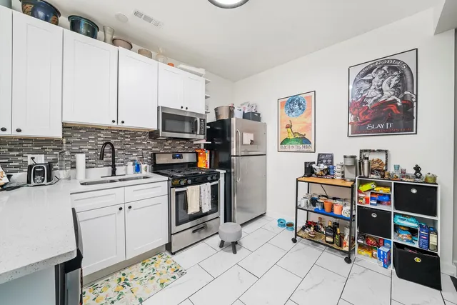 a view of kitchen with stainless steel appliances cabinets and a window