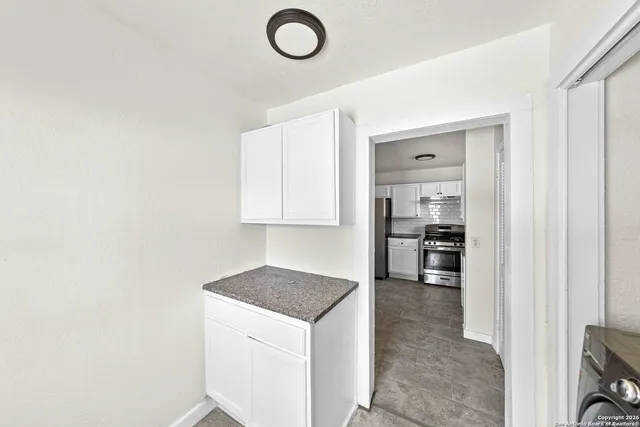 a kitchen with granite countertop a sink and a stove top oven