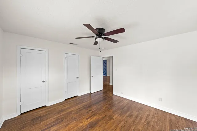 a view of an empty room with wooden floor