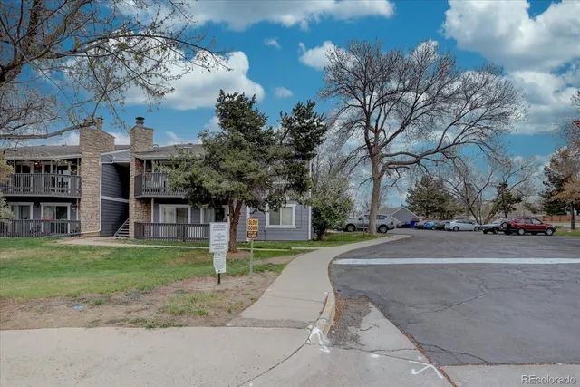a front view of a house with a garden and tree